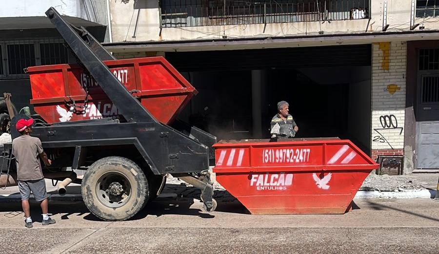 Equipe da Falcão Entulhos entregando caçamba em frente a um prédio
