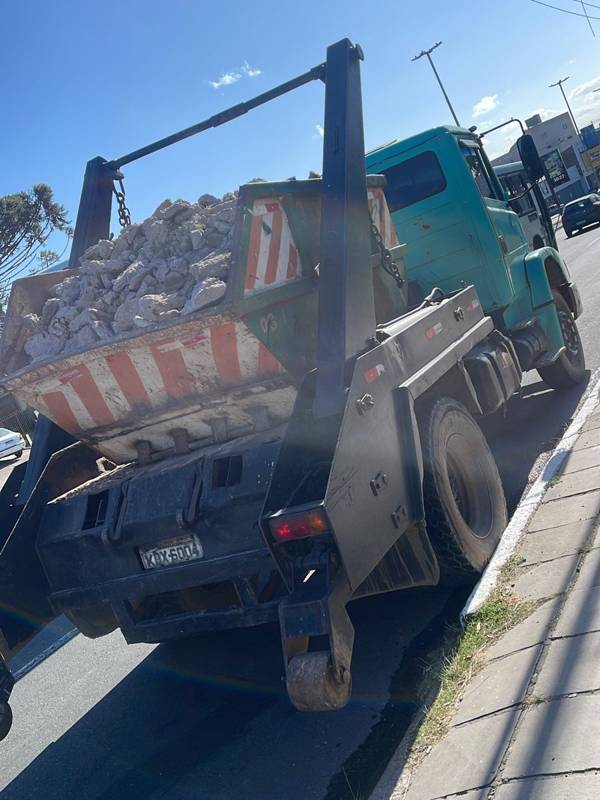 Caminhão da Falcão Entulhos transportando caçamba cheia de entulho